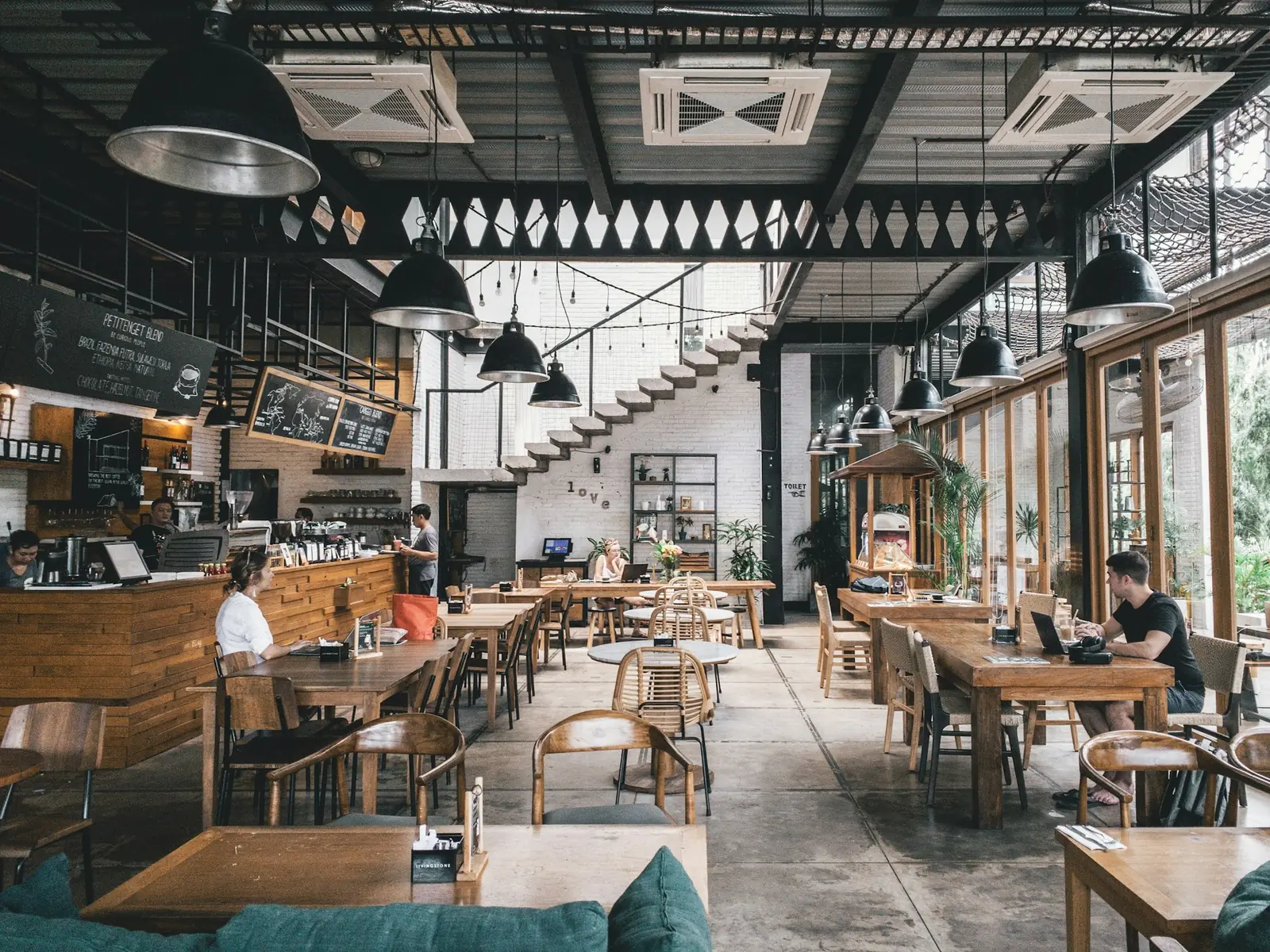 Ciepłe wnętrze restauracji z drewnianymi stołami i lampami o zmierzchu